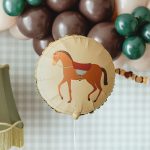 Konjić sa sedlom okrugli balon braon konj na bež pozadini