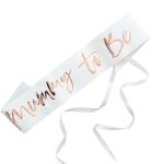 Lenta Mummy to be bela sa rose gold – bela papirna lenta sa velikim dominantnim rose gold cursive natpisom Mummy to Be i belim satenskim trakama