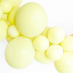 Mat svetlo žuti balon napunjen helijumom sa trakom i tegom